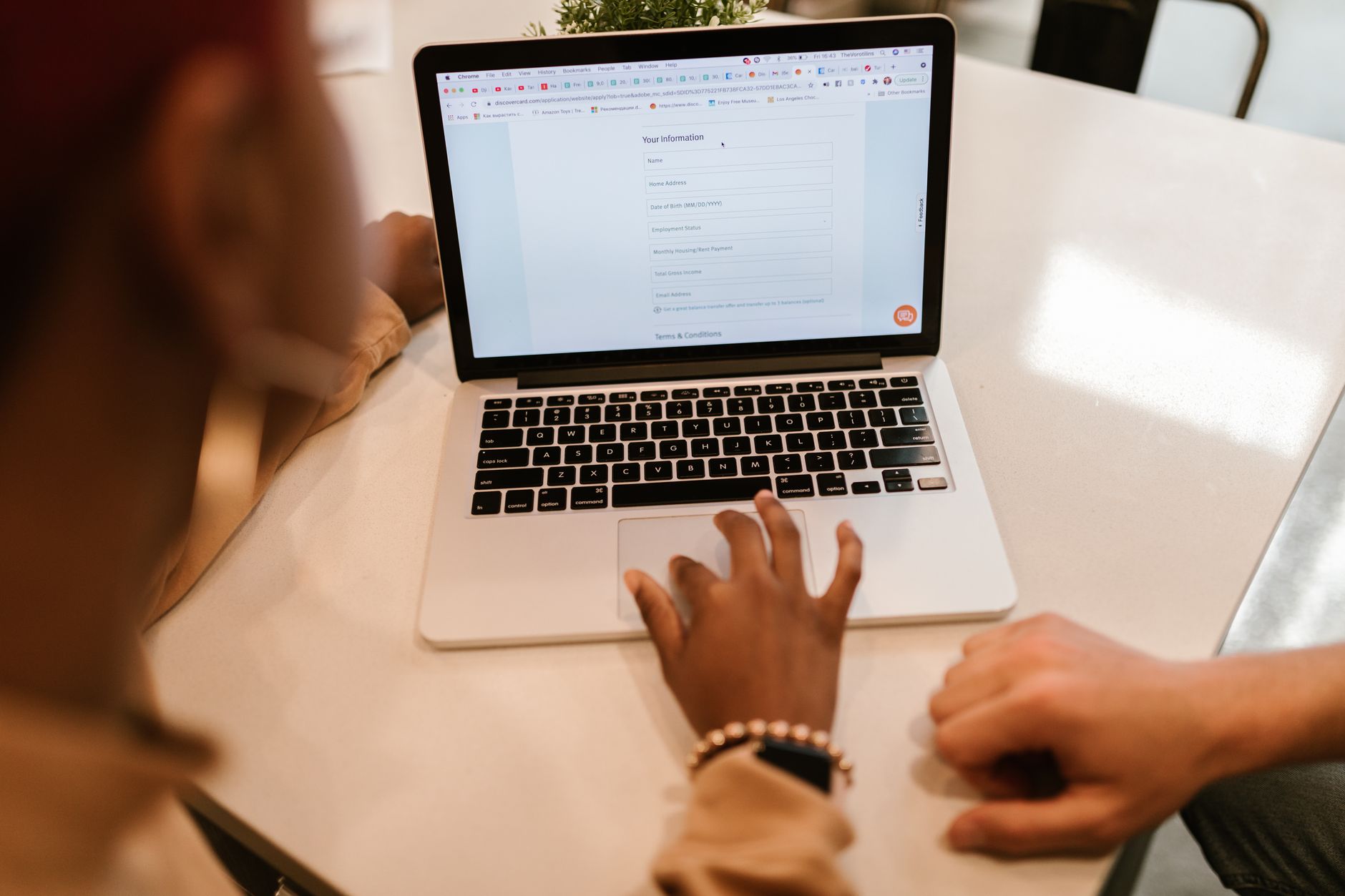 Nahaufnahme einer Person, die ein Online-Formular am Laptop ausfüllt