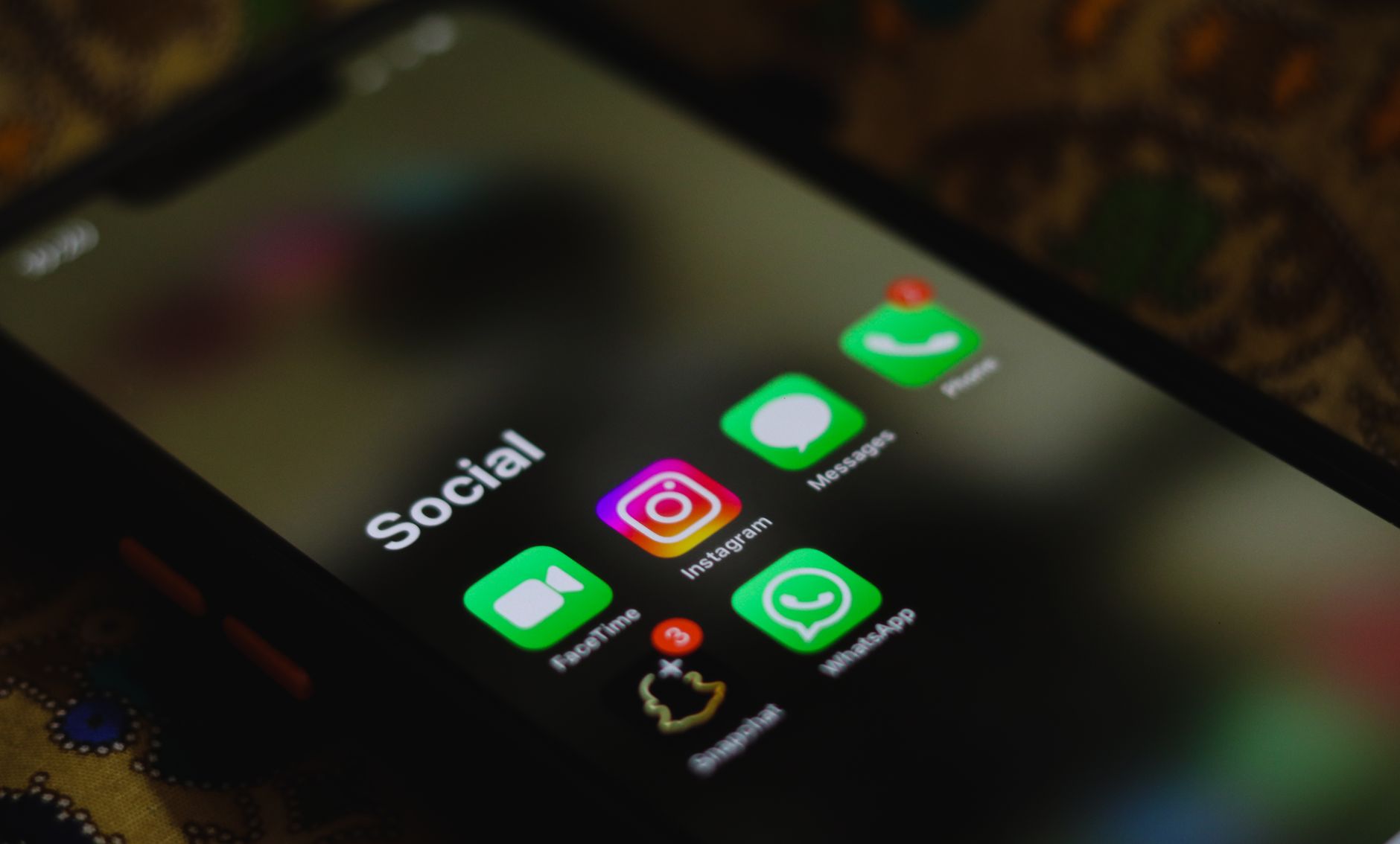 Smartphone mit Symbolen sozialer Netzwerke als Ausgangspunkt für Werbung auf Facebook