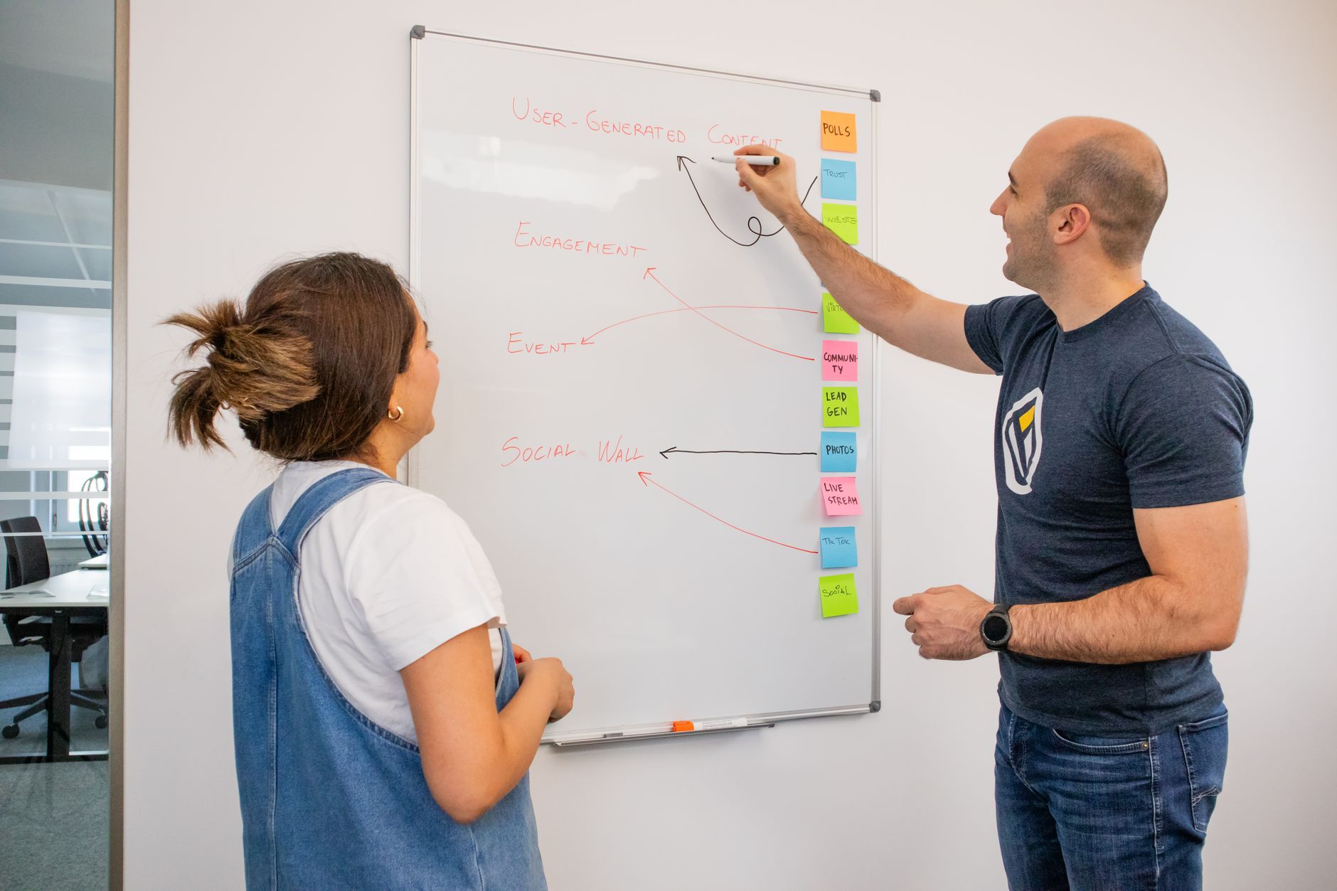 Zwei Kolleginnen entwickeln eine Marketingstrategie an einem Whiteboard im Büro