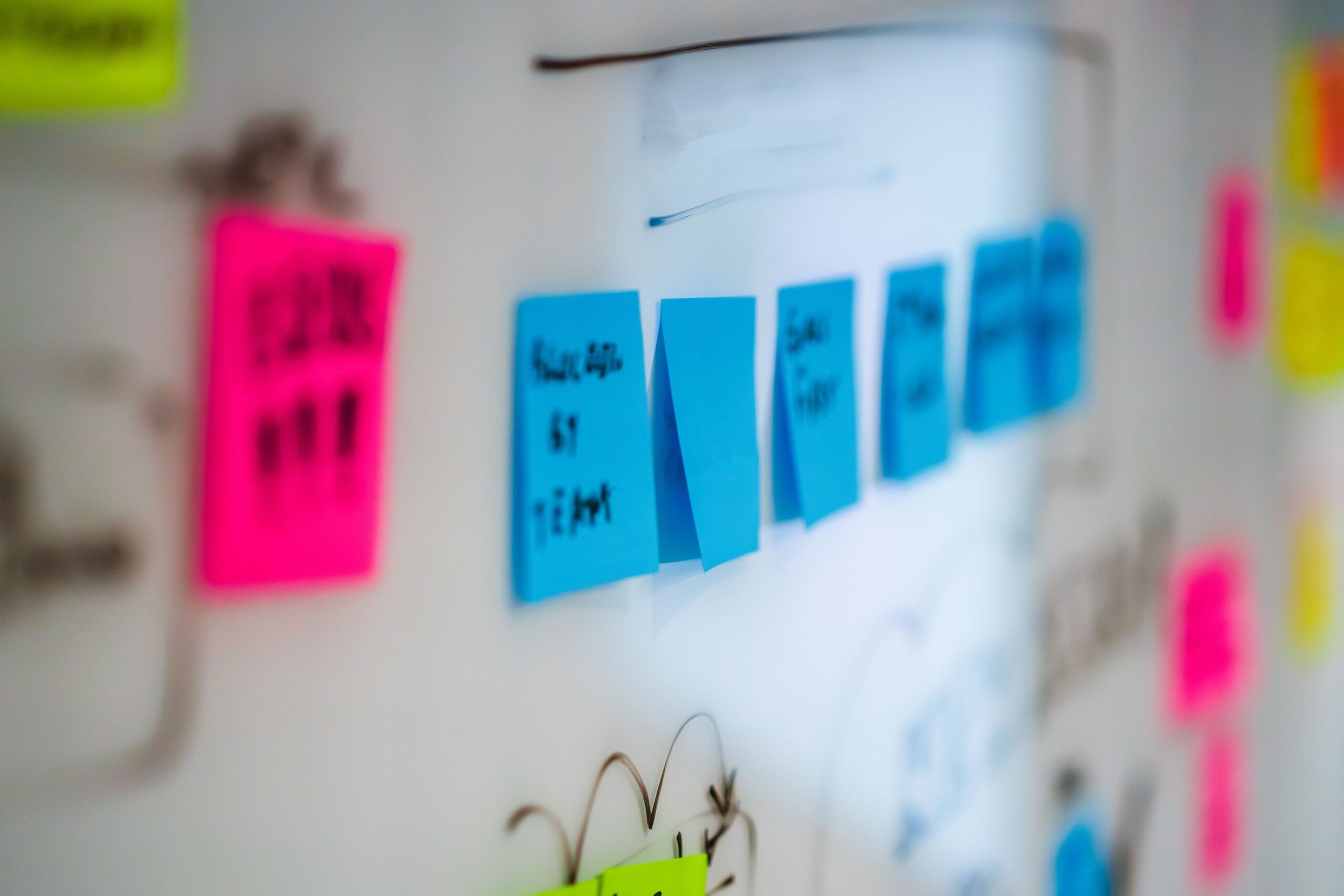 Haftnotizen in mehreren Farben an einem Whiteboard während eines Workshops