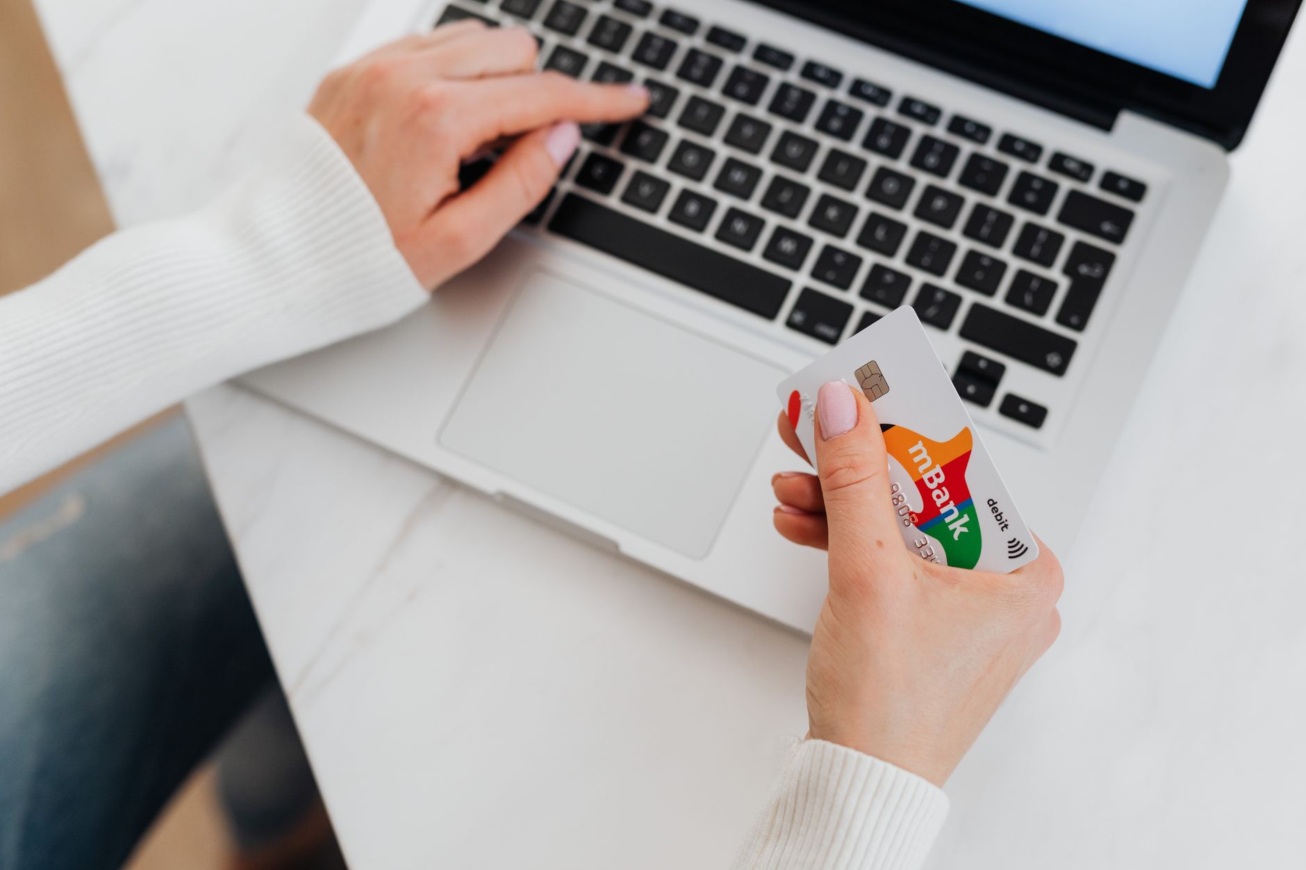 Person mit Kreditkarte am Laptop beim Hinterlegen der Zahlungsdaten für Google Ads
