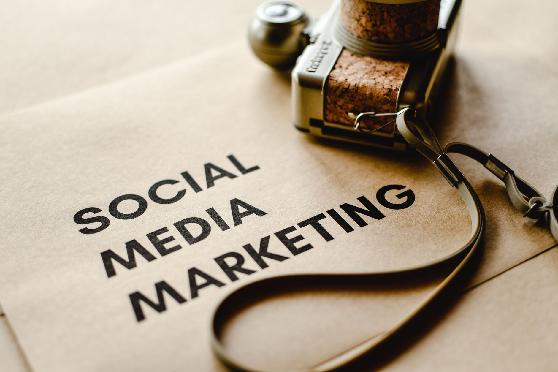 Unterlagen zur Social-Media-Werbung mit Kamera auf dem Schreibtisch bei der Kampagnenplanung
