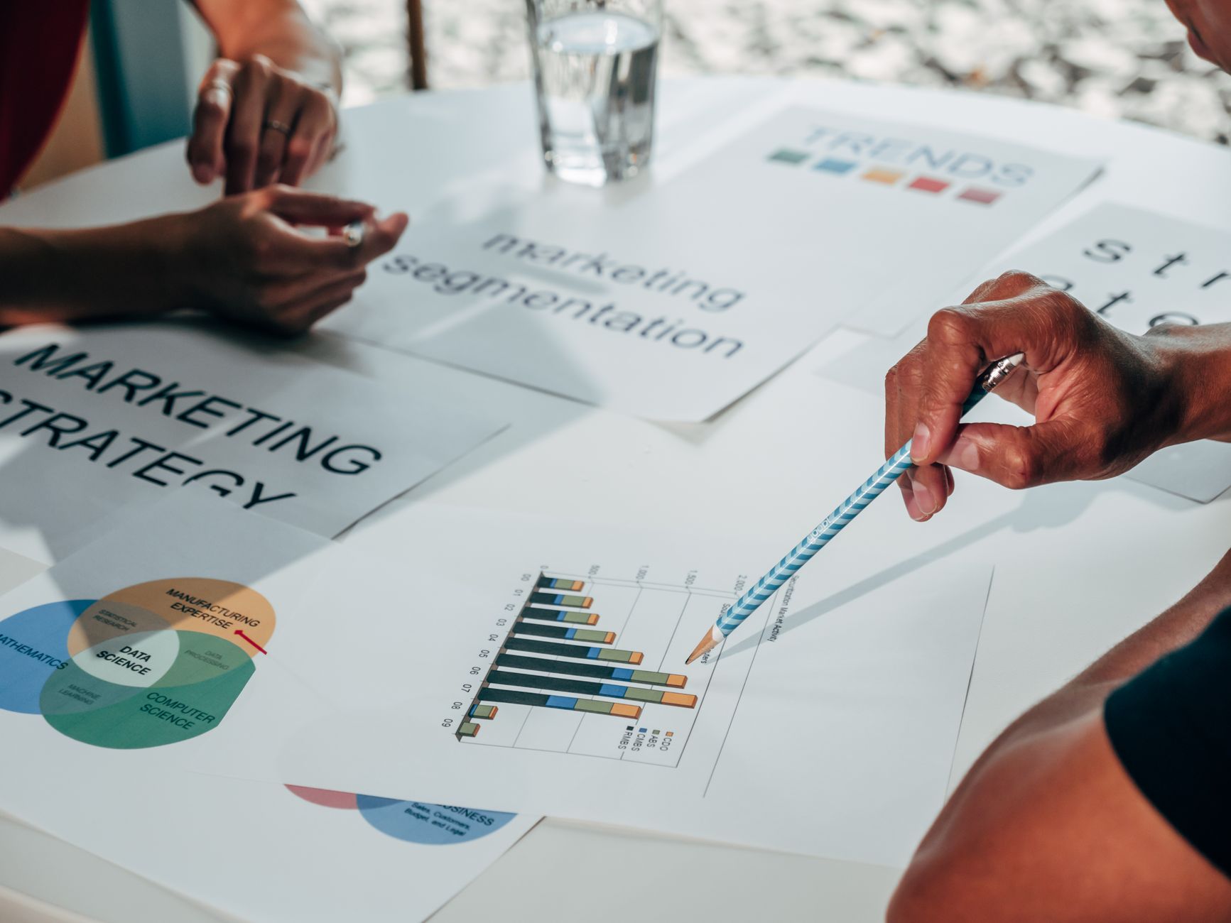 Team bespricht Marketingstrategie mit Datendiagrammen und Unterlagen in einem Büro
