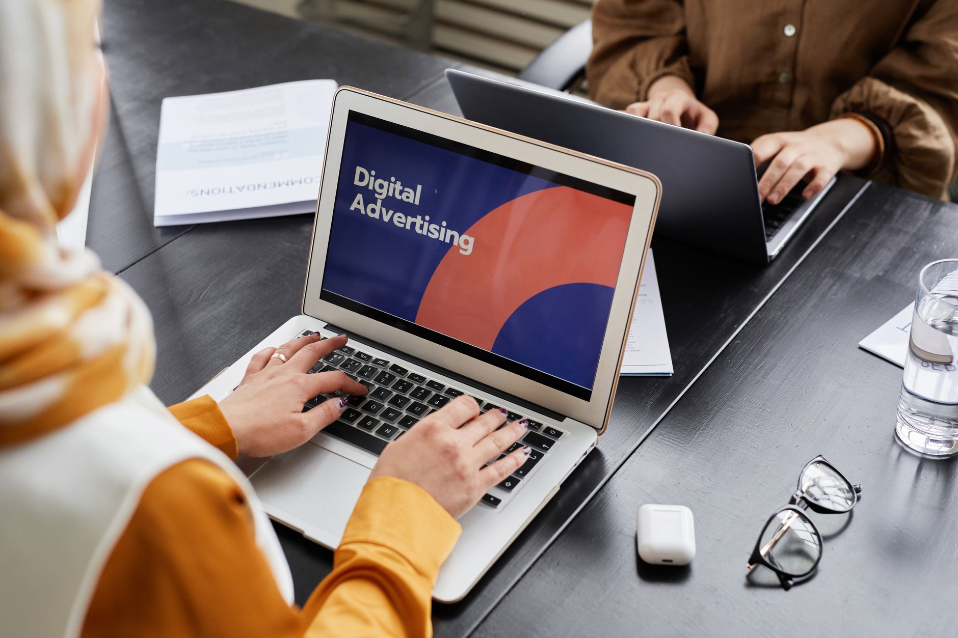 Zwei Mitarbeiter planen am Laptop eine Kampagne für digitale Werbung im Büro